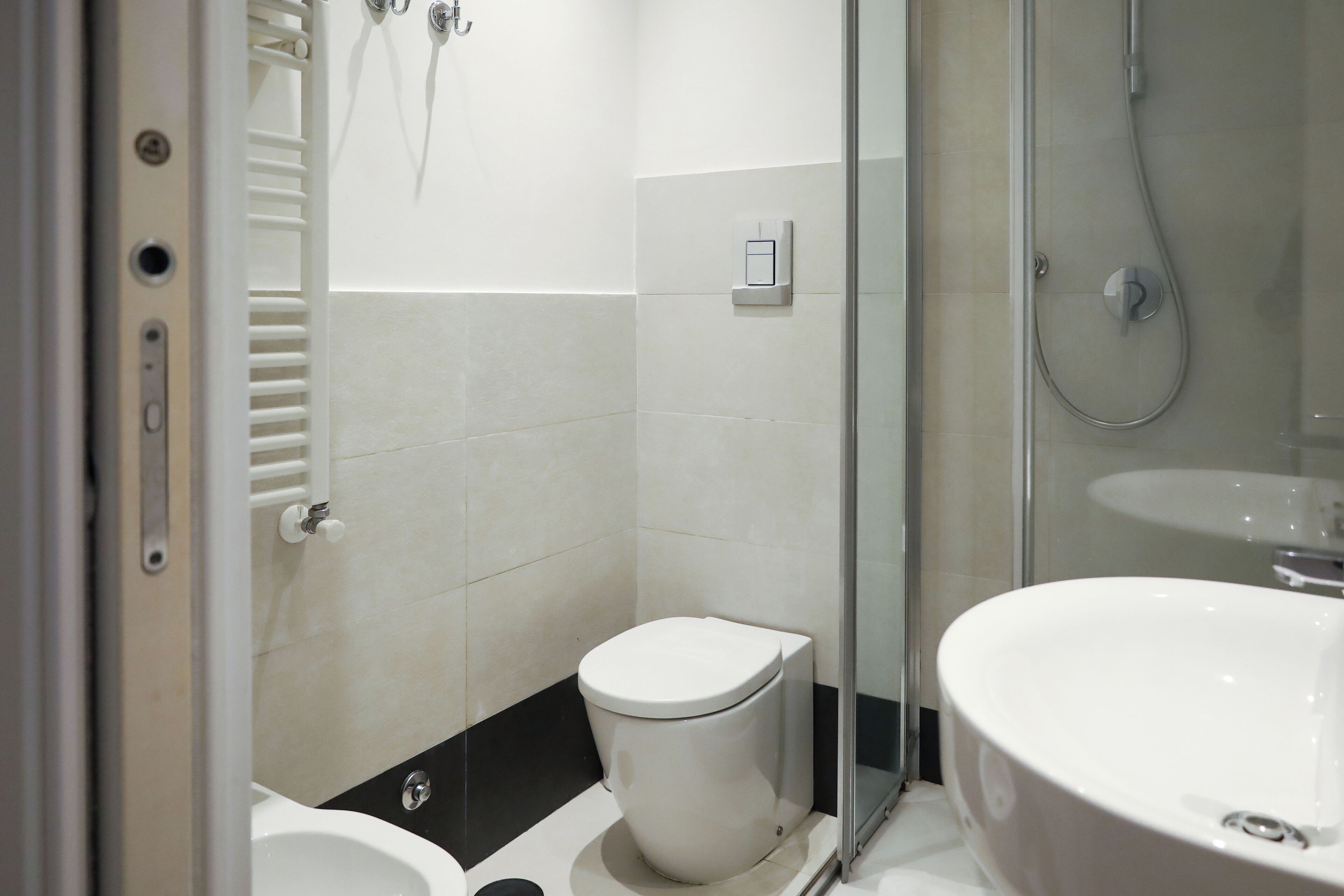 A bathroom with a toilet, a shower, and a sink.