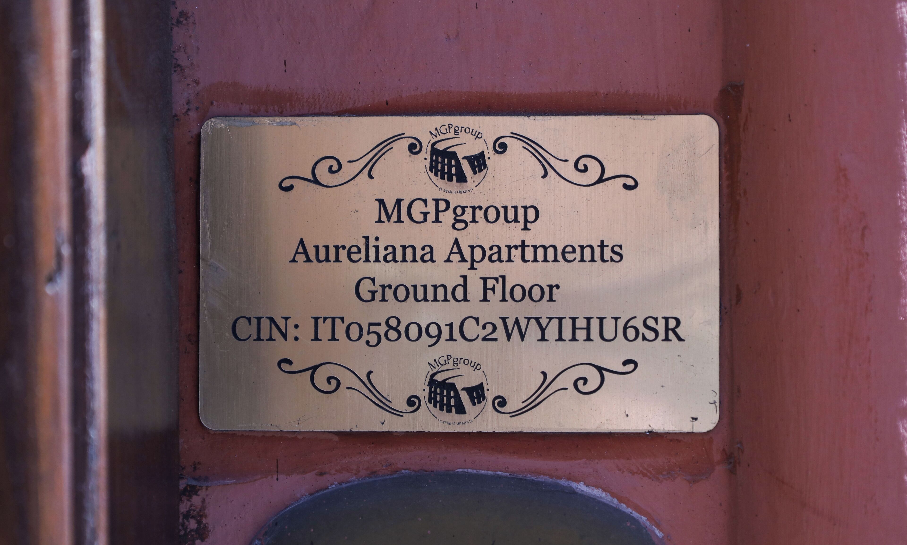 A sign for MGPgroup Aureliana Apartments on the Ground Floor with a CIN number.