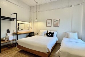 A hotel room with a large bed, a desk with a chair, a mirror, and two bedside tables with towels. - The51Hometel (Chiangmai)