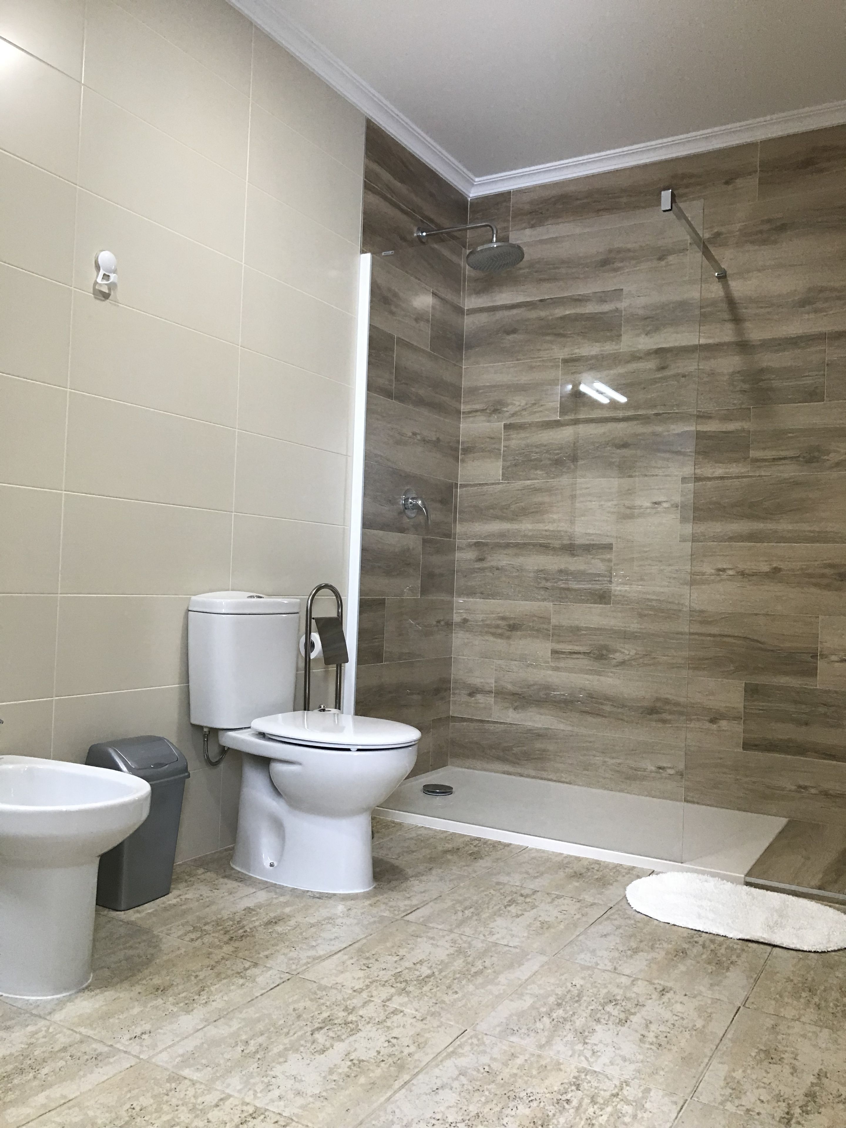 Un baño moderno con inodoro, bidé y zona de ducha.