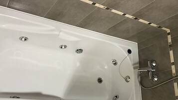 A modern bathroom with a freestanding bathtub, a glass shower enclosure, and a toilet.