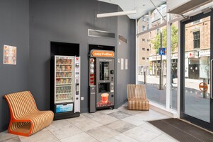 Un distributeur de café et un espace détente avec une chaise et un banc.
