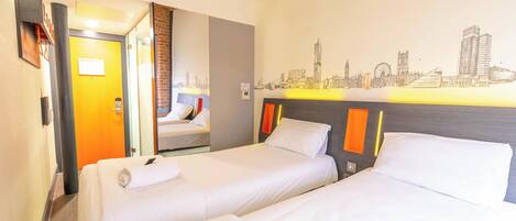 A hotel room with two beds, a cityscape mural, an air conditioning unit, and a door leading to another room.