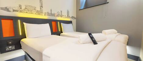 A hotel room with two beds, a cityscape wall art, a TV mounted on the wall, and a window with a view.