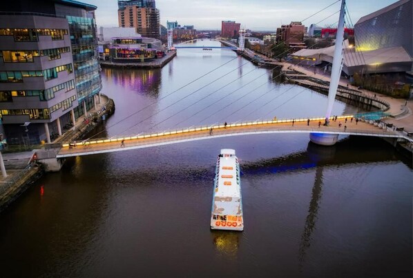 A river with a bridge, buildings, and a boat.