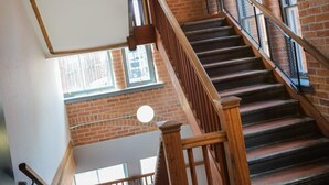A staircase with wooden railings and brick walls, leading to an upper floor. - easyHotel Manchester (Manchester)
