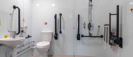 Un baño moderno con inodoro, lavamanos y ducha.