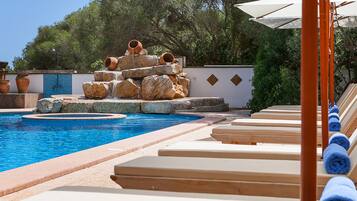 Una piscina al aire libre, tumbonas