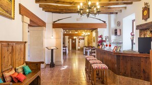 Un vestíbulo de hotel con bancos de madera, un mostrador de recepción y un candelabro.