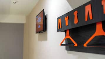 A wall-mounted television and a black and orange wall art piece.