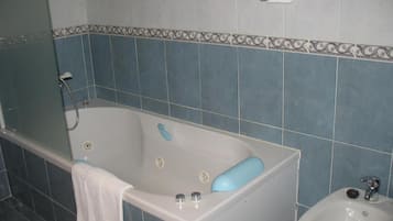 Un baño con bañera, bidé y lavamanos.