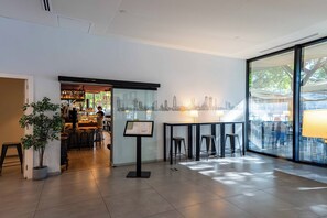 A modern interior with a bar area, seating, and a cityscape mural. - easyHotel Barcelona Fira (L'Hospitalet de Llobregat)