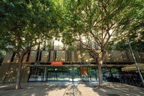 A hotel entrance with a glass facade, a sign for 'easyHotel,' and a nearby restaurant named 'COMARCA.' - easyHotel Barcelona Fira (L'Hospitalet de Llobregat)