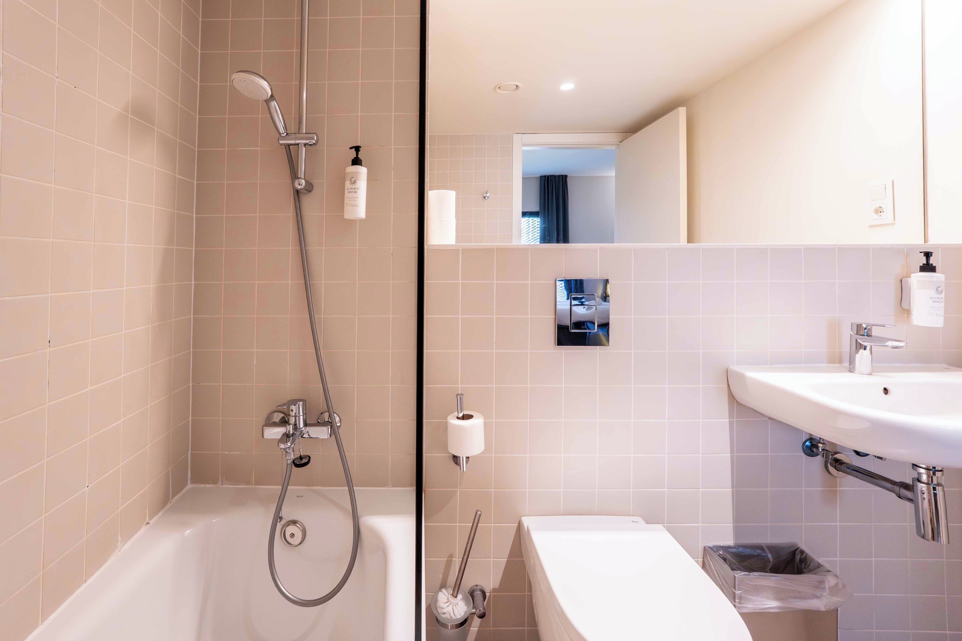 A modern bathroom with a bathtub, shower, toilet, and sink.