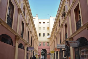 A narrow street with buildings on either side, featuring balconies and awnings. - Hostal Guestped (Madrid)