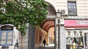 A street view with a shop on the right displaying furniture and a sign for 'Pelquería, Trenzas, Aplicación de Extensiones'. - Hostal Guestped (Madrid)
