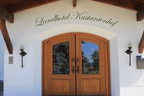A double wooden door with glass panels and a sign above reading "Landhotel Kastanienhof". - Landhotel Kastanienhof (Georgenberg)