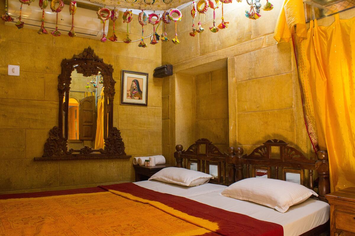A hotel room with two beds, a large mirror, and a picture on the wall.
