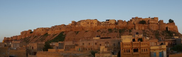 Una fortaleza histórica con varios niveles y una estructura destacada en la cima de una colina.