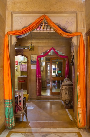 Uma entrada com um arco tradicional, um banco e uma escultura em pedra.