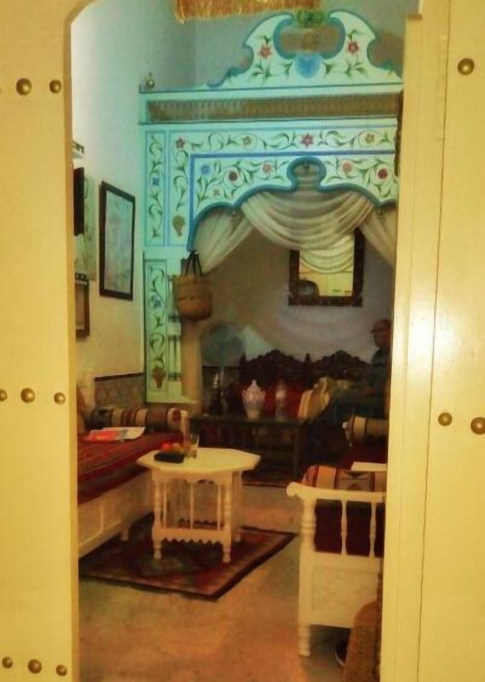 Un salón acogedor con sofá, sillones, una mesita y un techo decorativo.