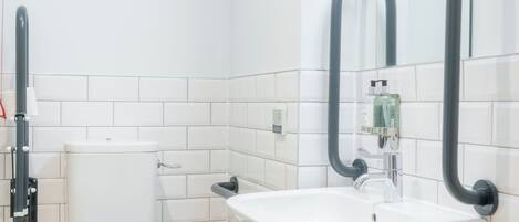 A modern bathroom with a toilet, sink, and mirror.