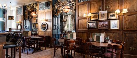 Un comedor tradicional con muebles de madera, candelabros y cuadros en las paredes.