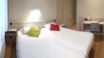 Une chambre d’hôtel avec un lit, un bureau et une chaise.