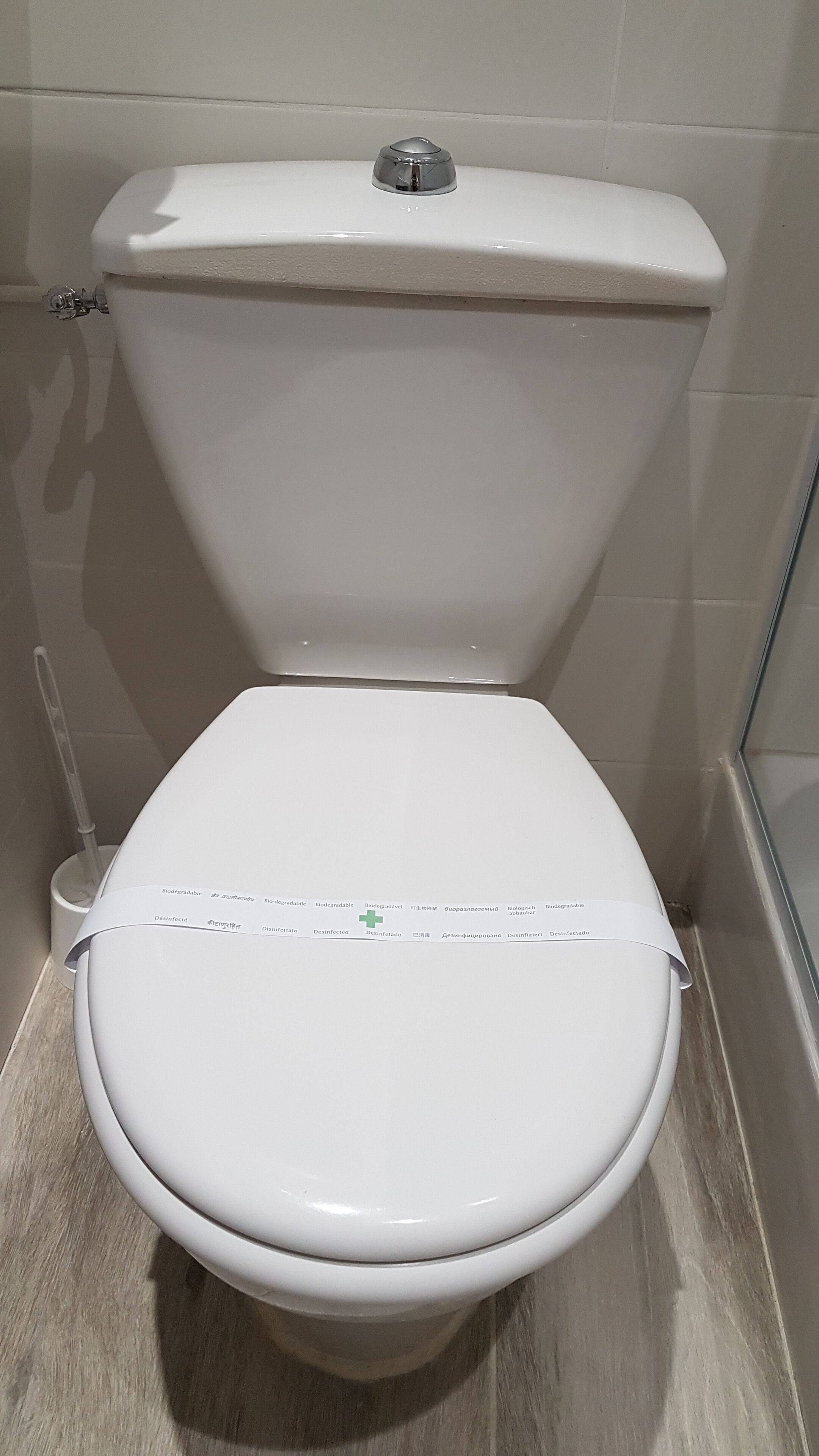 Μια λευκή τουαλέτα με καπάκι και ενσωματωμένη λειτουργία μπιντέ.