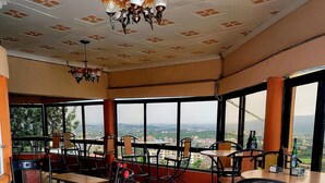 Un restaurante con terraza, suelo de baldosas y vistas a la ciudad.