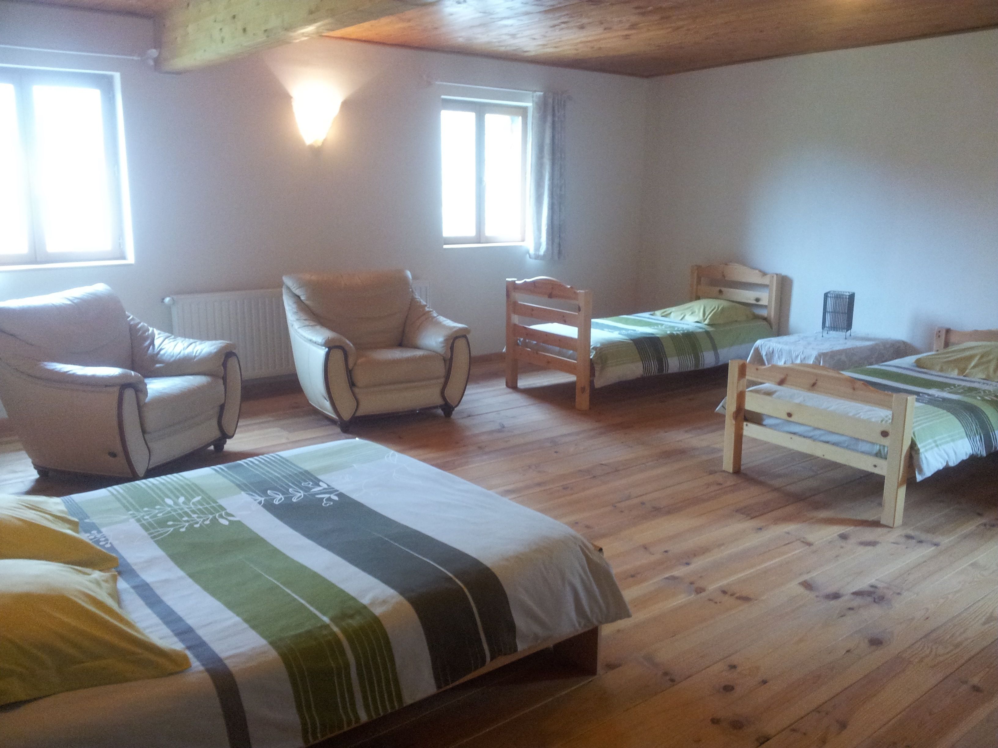 Een kamer met twee bedden, een stoel en een radiator.