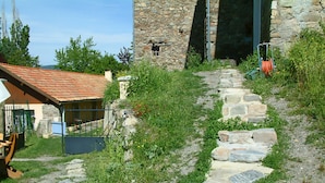 Una scala in pietra conduce a un edificio con tetto in tegole rosse.