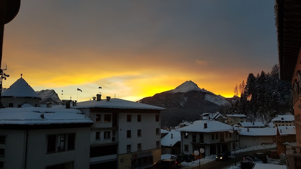A snow-covered village with buildings and a mountain in the background. - Locanda ai Dogi (Pieve di Cadore)