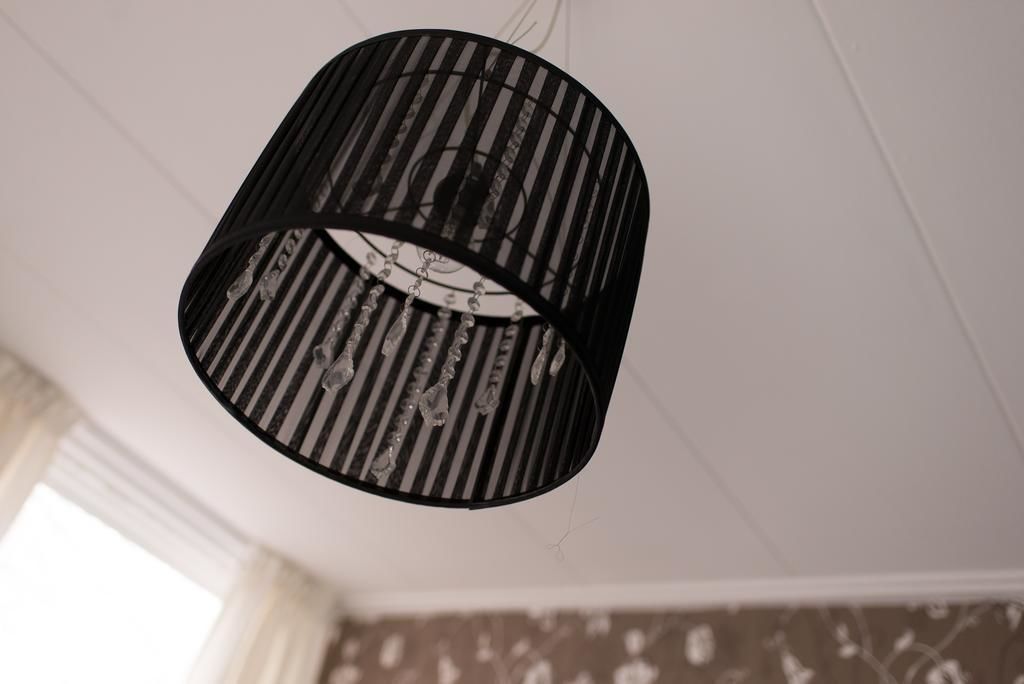 Een zwarte, cilindrische hanglamp met ribbels.