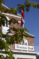 Un letrero de hotel con el nombre 'Brondums Hotel' y una bandera en la parte superior.