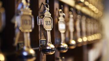 A row of numbered brass door knockers on a wooden door, indicating room numbers.