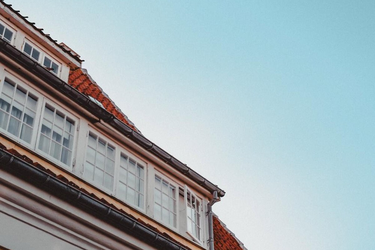 A building with a red-tiled roof and white window frames.