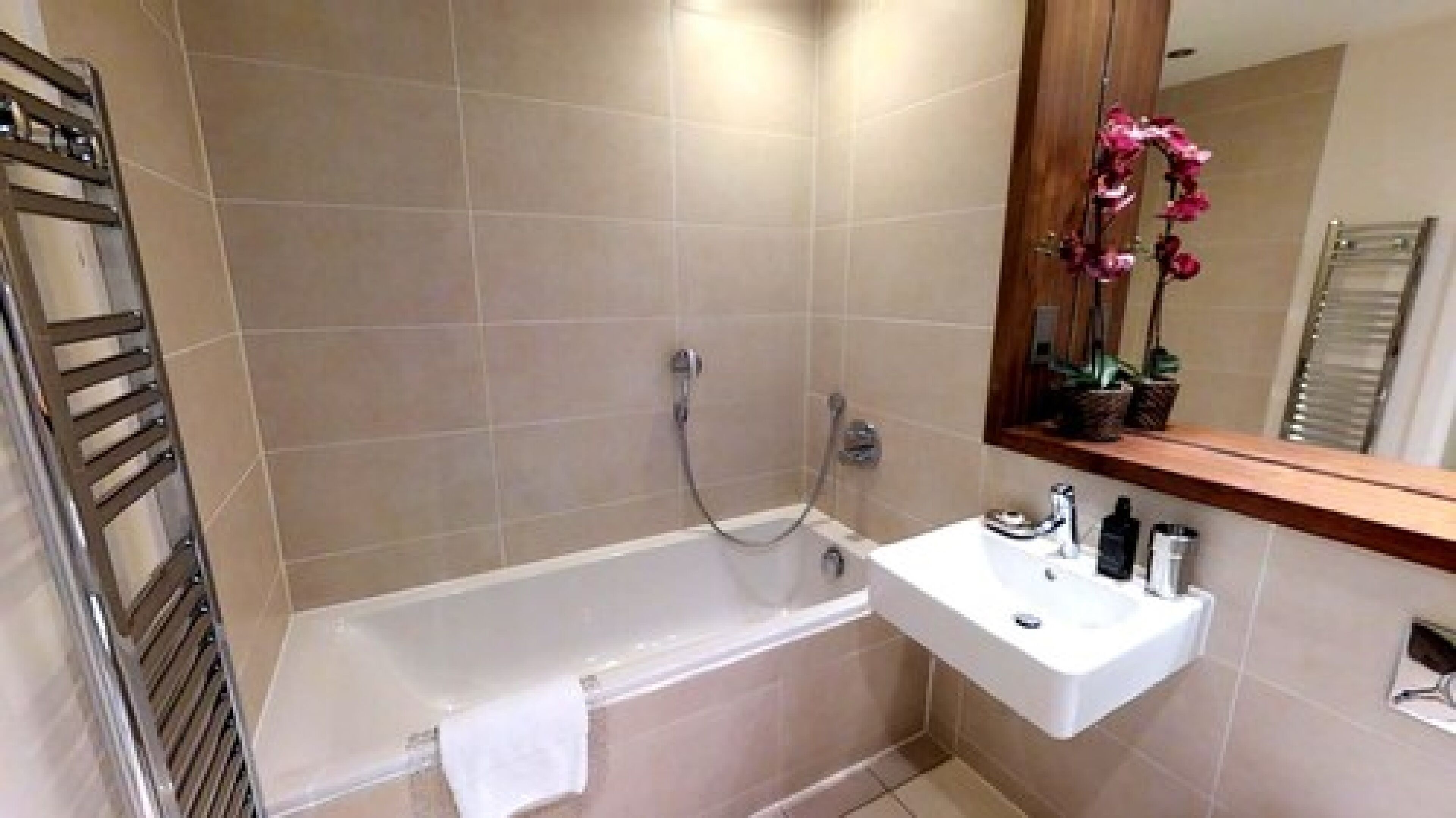 A bathroom with a bathtub, a sink, and a mirror.