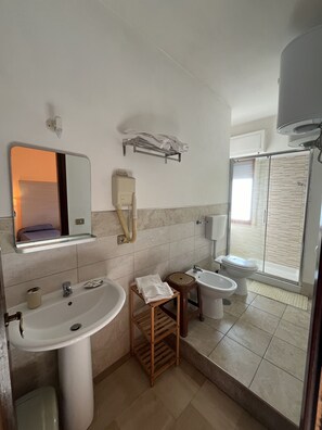 A bathroom with a sink, two basins, a mirror, a towel rack, and a shower area. - Hotel L'Approdo (Brindisi)