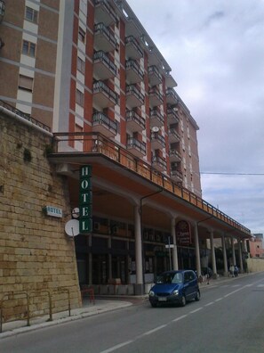 A hotel with a red and white facade, multiple balconies, and a sign indicating a restaurant. - Hotel L'Approdo (Brindisi)