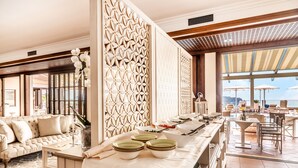 A spacious dining area with a long counter, white tablecloths, and a decorative partition with intricate patterns. - Residence Madrigale (Costermano sul Garda)