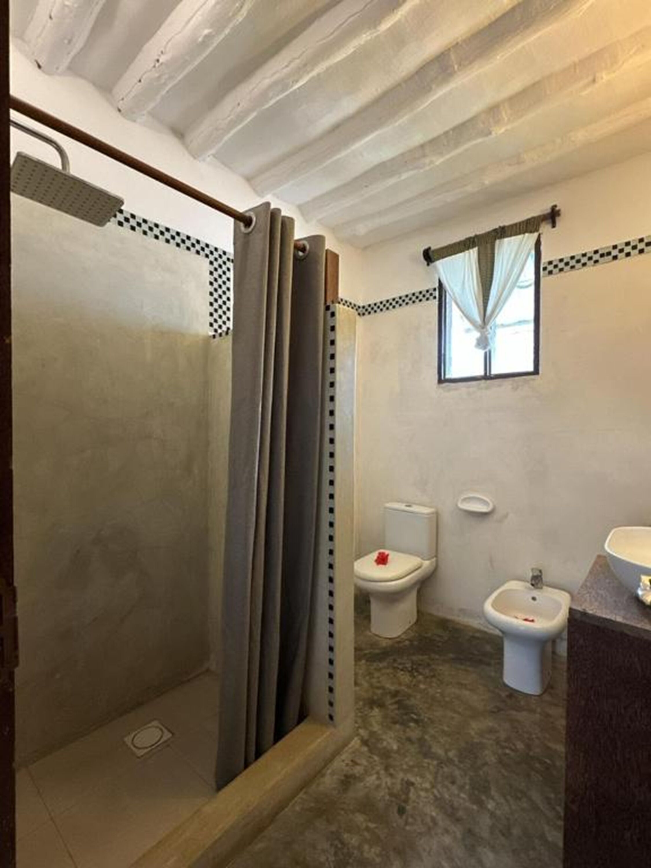 Ein Badezimmer mit Dusche, Toilette, Bidet und Waschbecken.