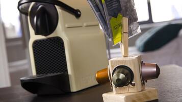 Una cafetera con base de madera y cuerpo negro y beige.