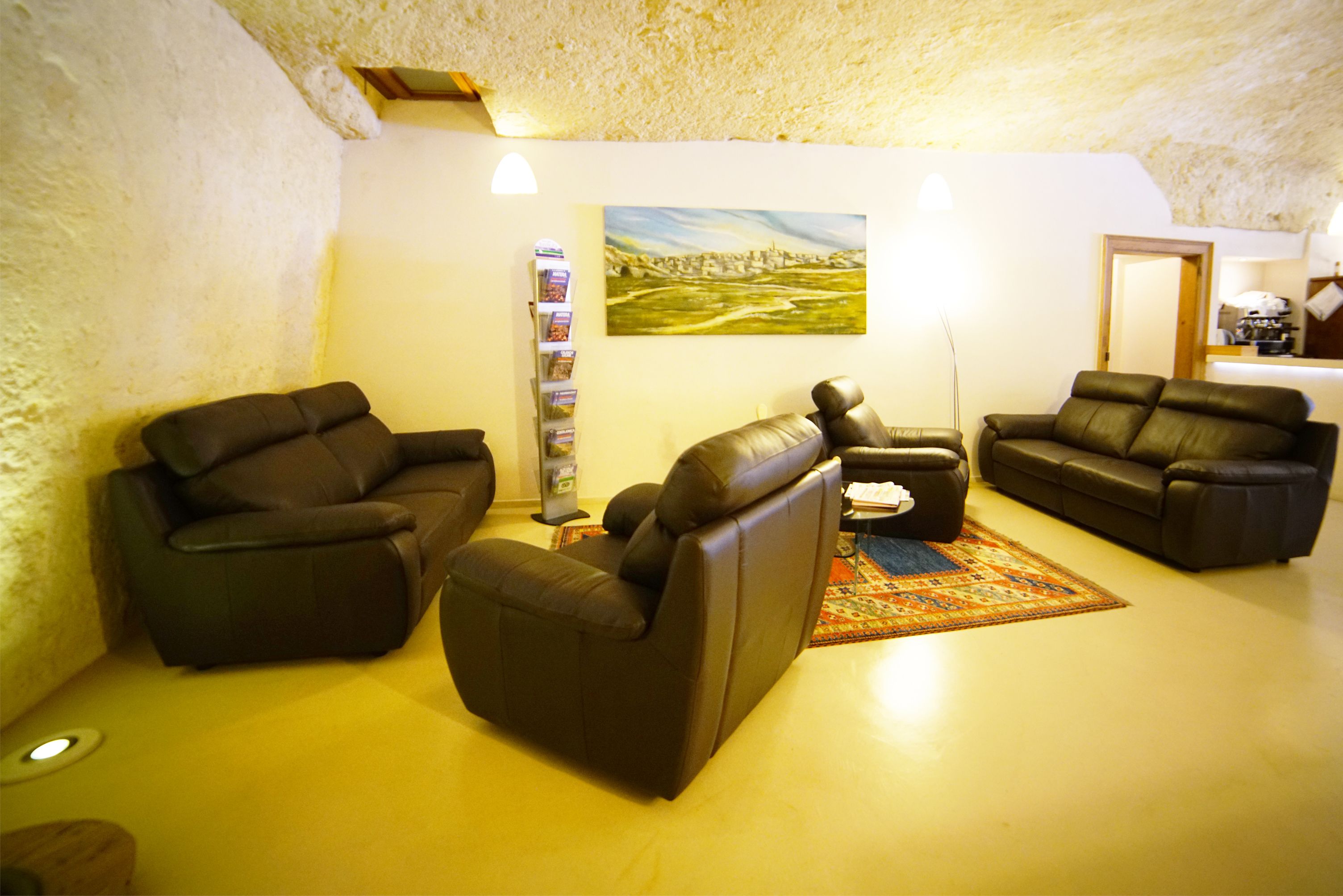 A cozy living room with two leather sofas, a coffee table, and a painting on the wall.