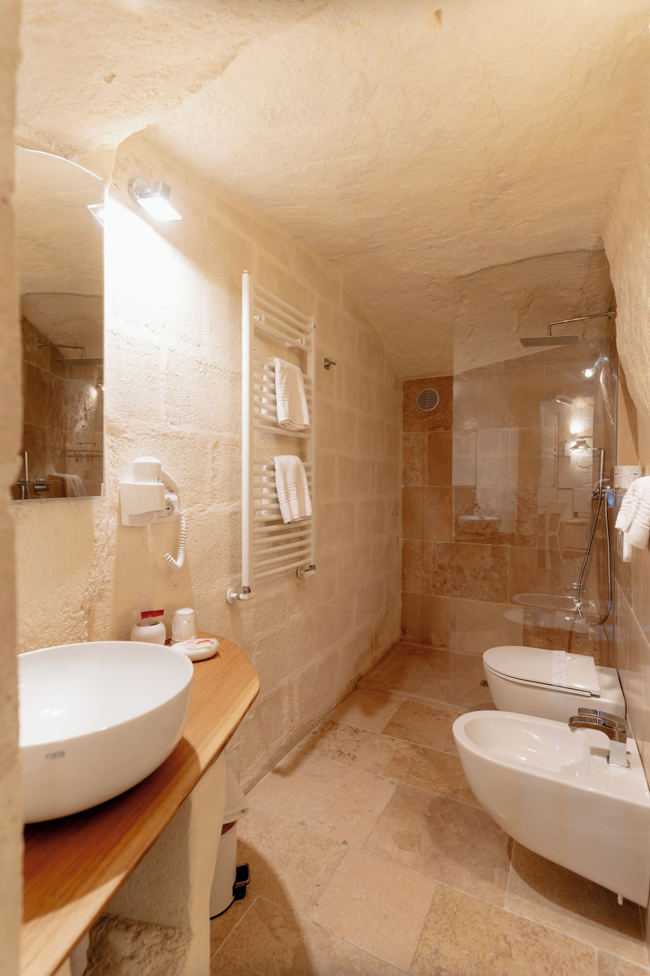 A bathroom with a large sink, a bidet, and a shower area.
