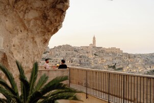 Varanda com vista para uma cidade histórica, destacando uma torre de igreja.