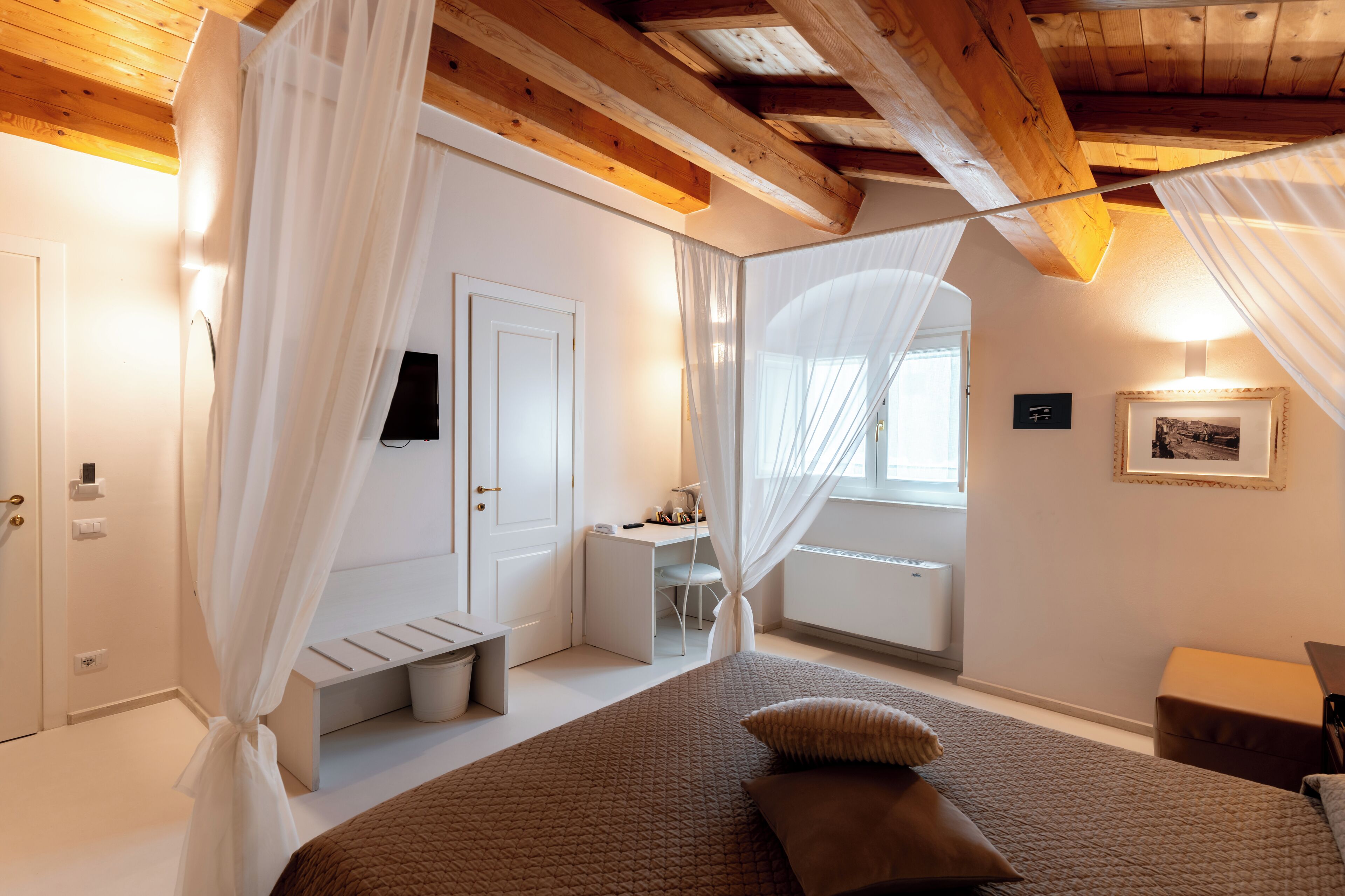 A bedroom with a bed, a desk, a chair, and a window.