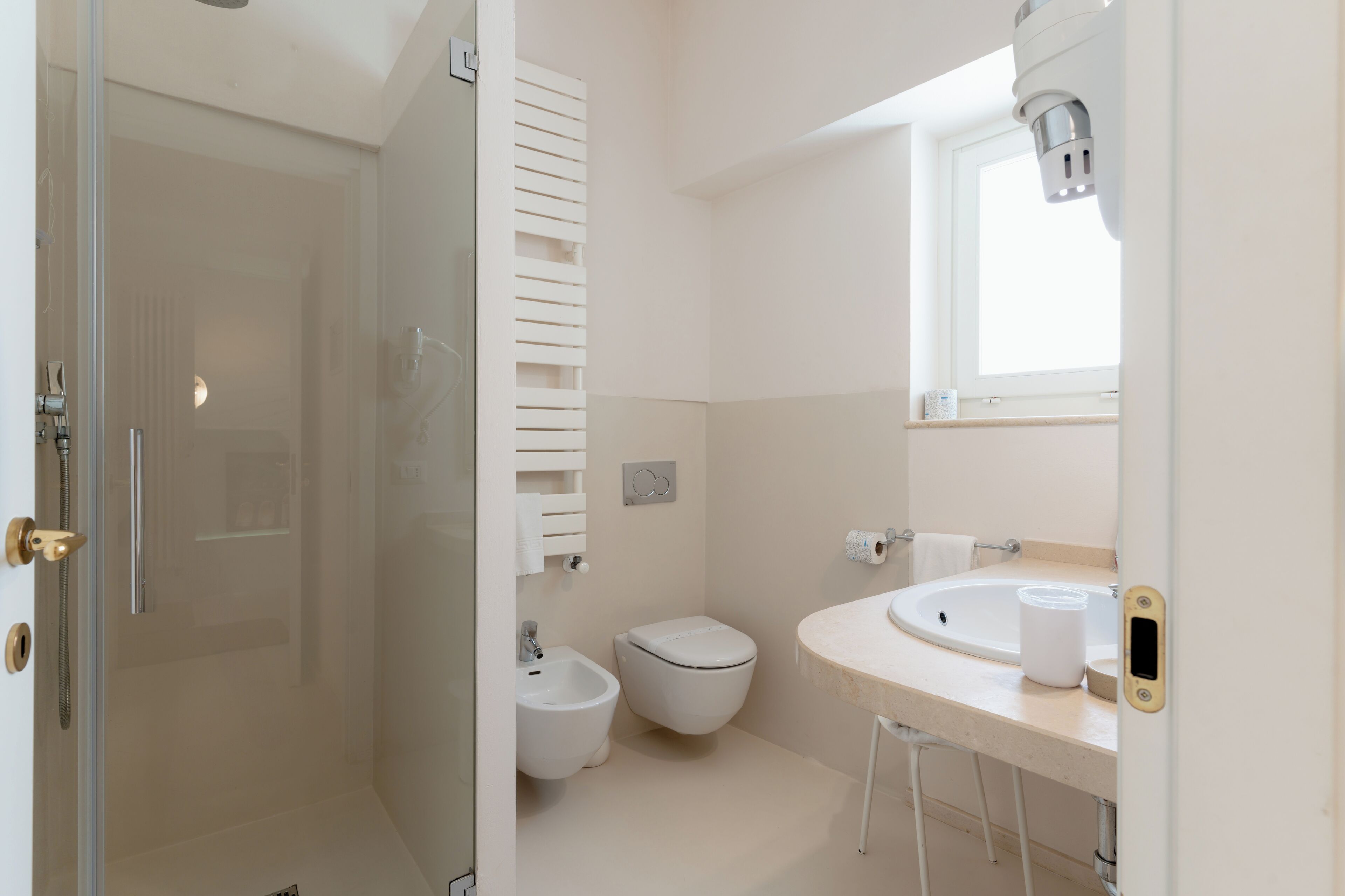A modern bathroom with a glass shower enclosure, a toilet, and a sink with a mirror above it.