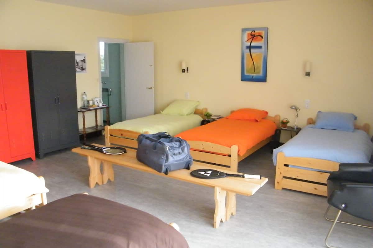A room with two beds, a desk, and a wardrobe.