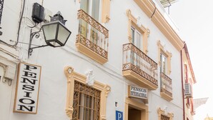 A building with a sign reading "PENSION INTERNACIONAL" and a blue parking sign. - Pension Internacional (Córdoba)
